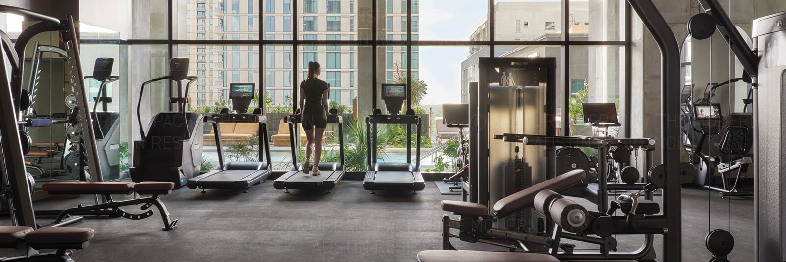 A woman on a treadmill in the fitness center at The Modern Austin Residences