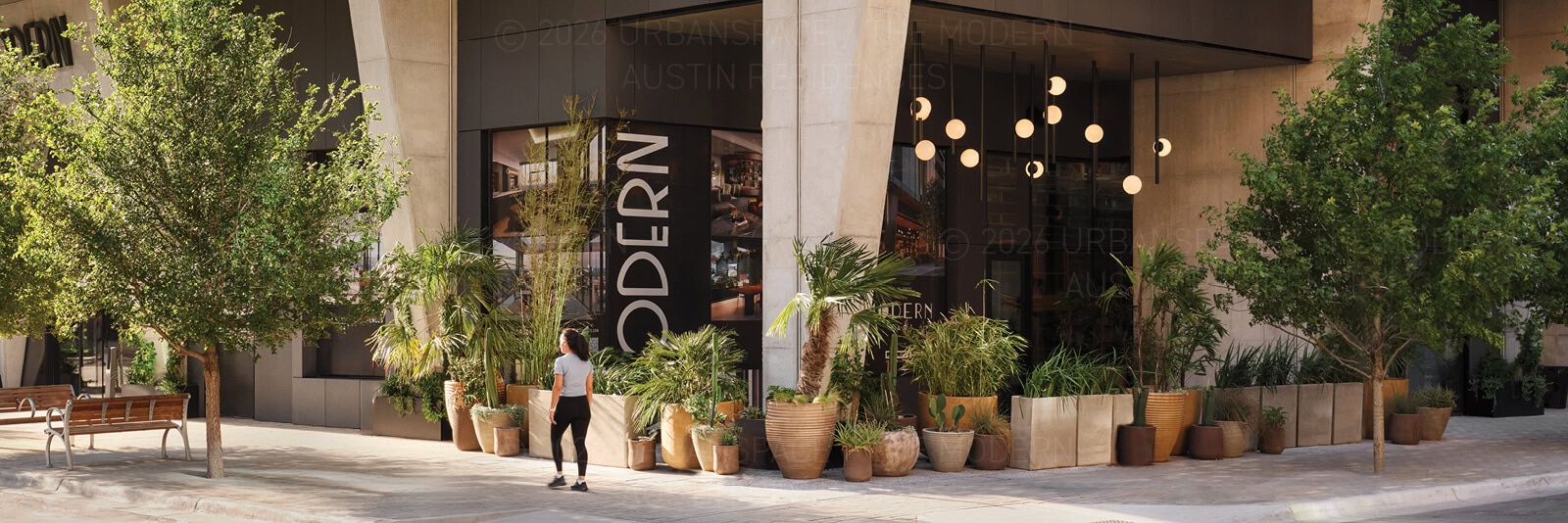 A woman walks by the exterior of Modern Bar at The Modern Austin Residences