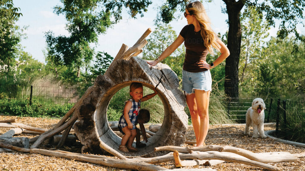 A mother and child with dog on a playground at Rainey Street Trailhead Park