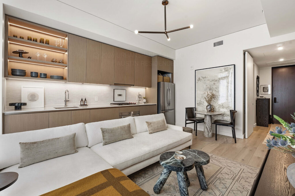 Modern condo living room with sofa and efficient kitchen