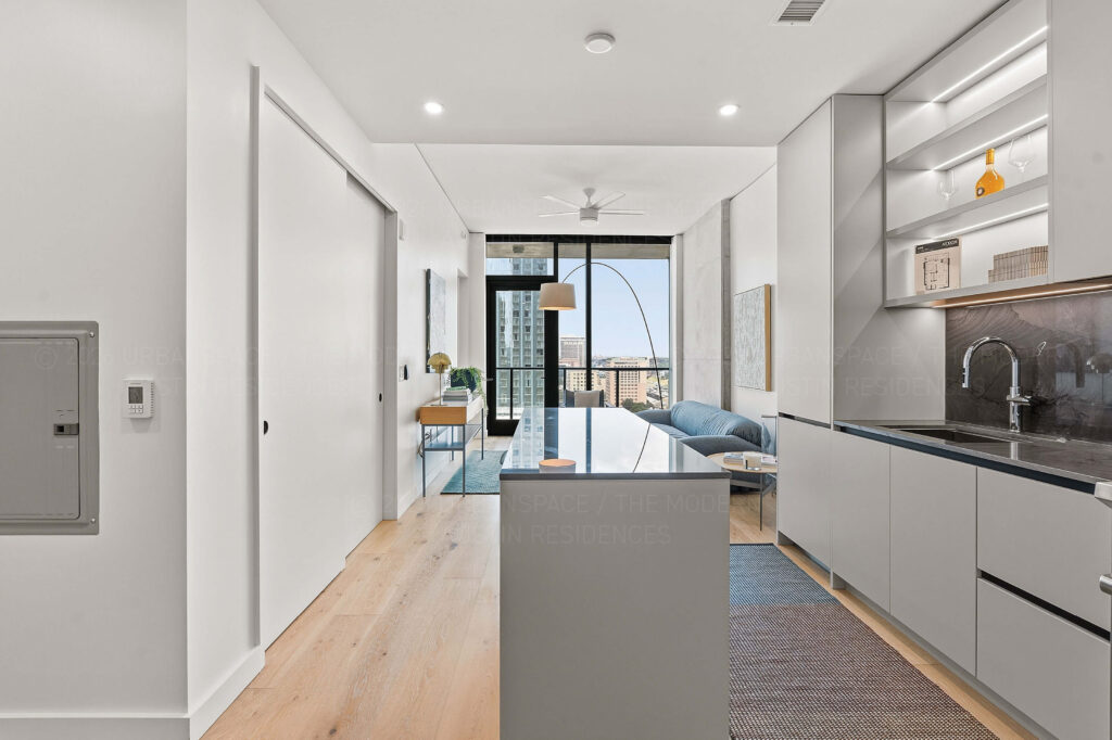Modern condo kitchen looking towards living room