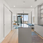 Modern condo kitchen looking towards living room